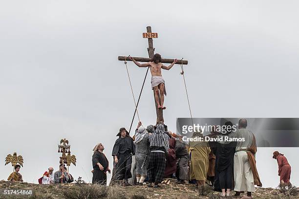An actor portraying Jesus is crucified as residents of Hiendelaencia dressed in period clothing perform during the reenactment of Christ's suffering...