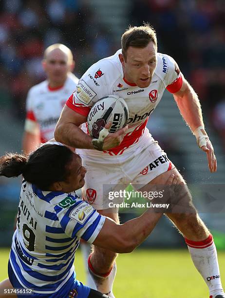 James Roby of St Helens is tackled by Taulima Tautai of Wigan Warriors during the First Utility Super League match between St Helens and Wigan...