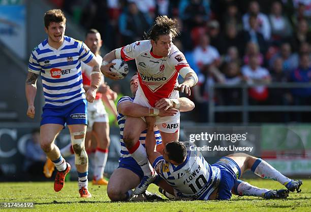 Louie McCarthy-Scarsbrook of St Helens is tackled by Ben Flower of Wigan Warriors during the First Utility Super League match between St Helens and...