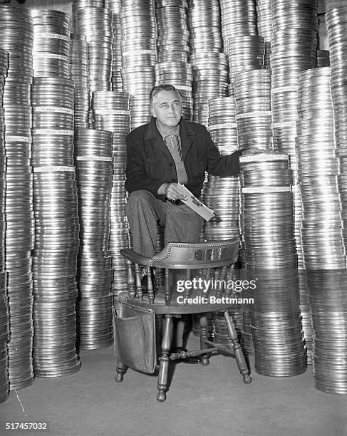 Mervyn LeRoy, currently directing Toward the Unknown, a Teluca Productions picture for Warner Bros., is seen here beside hundreds of cans containing...