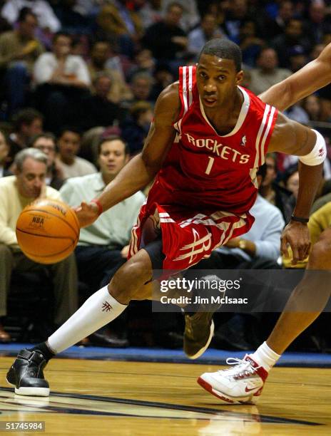 Tracy McGrady of the Houston Rockets drives down the court against the New Jersey Nets on November 15, 2004 at the Continental Airlines Arena in East...