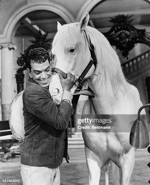 Mario Moreno Reyes hugging white stallion in a scene from the 1960 film Pepe.