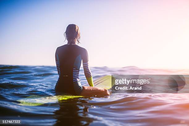 surfer girl - sitting on surfboard stockfoto's en -beelden