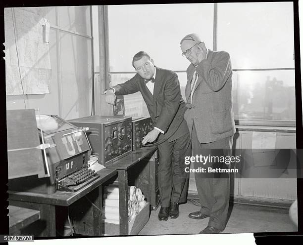 Dix, right, of the Dix Newspapers of Ohio, is shown here in the United Press Asia Division headquarters in Tokyo where United Press monitors the...