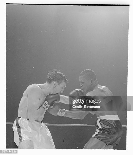 Defending welterweight champion Carmen Basilio trades punches with challenger Johnny Saxton during the third round of their title bout here, March...