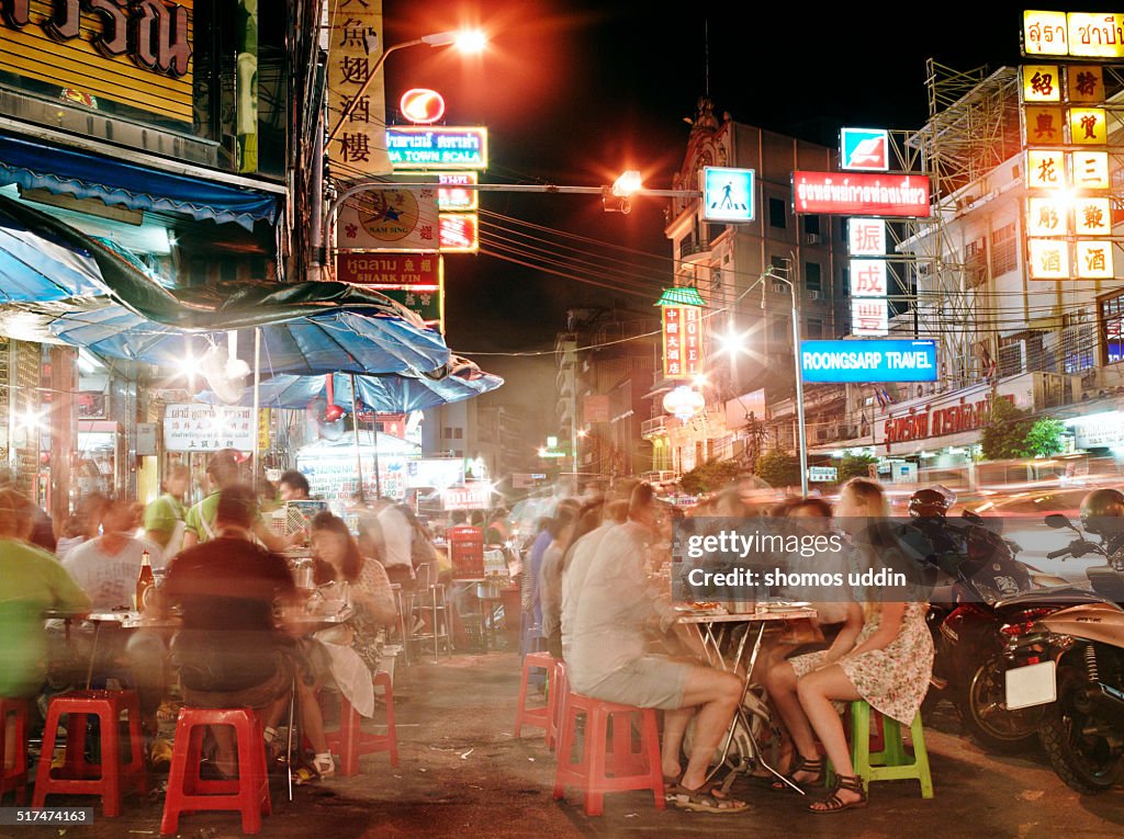 People dining outside at food stalls at night