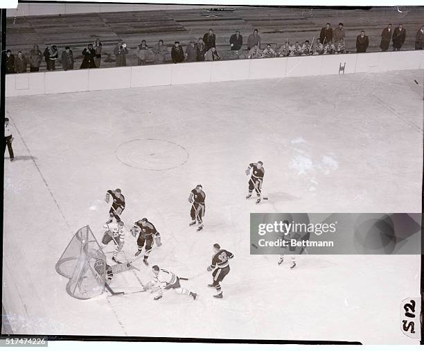 Jim Logan of Toronto, member of the Canadian Olympic Hockey Team, drives the puck in the net past German goalie Jansen Ulrich in the second period...