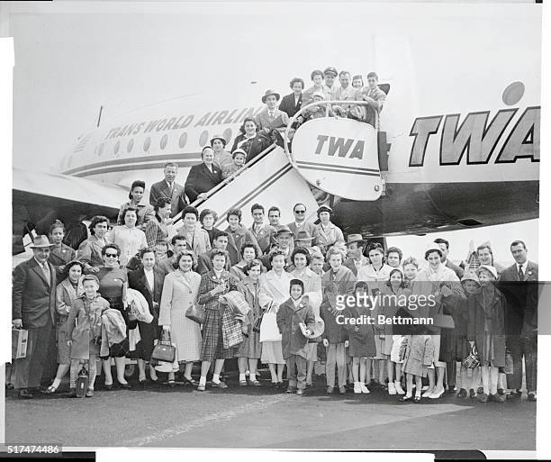 Group of 52 Italian refugees, all of them tailors r seamstreses, pose in front of the TWA plane that brought them to idlewild airport here, April...