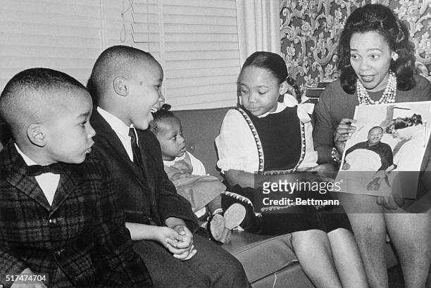 Mrs. Martin Luther King, Jr., explains that "Daddy's in the hospital," to her children as she shows them a picture of the integration leader and his...