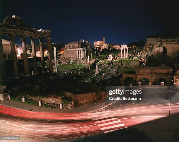 Rome, Italy: Night view of the ancient Roman Forum, heart of the eternal city with its temple ruins, Fora and columns. In the foreground, the lights...