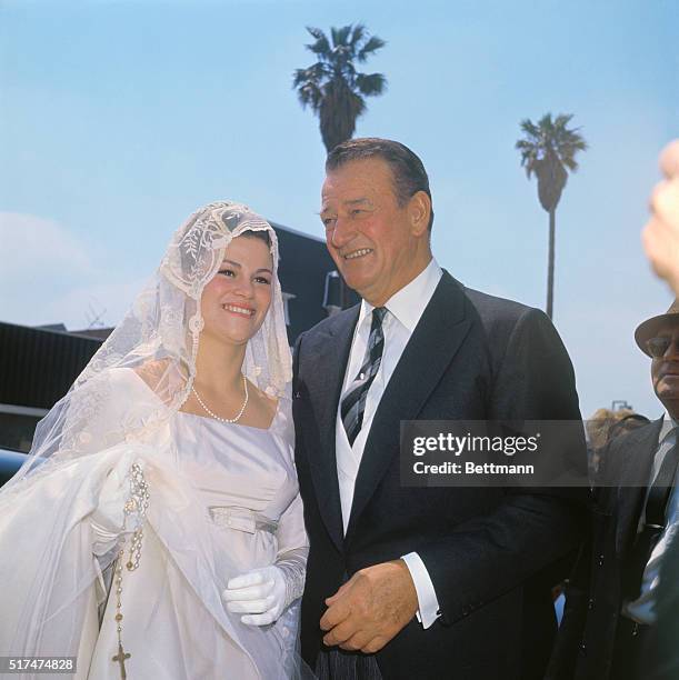 John Wayne with his daughter Melinda Ann on her wedding day. Her new husband is Gregory Robert Munoz.