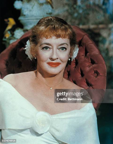 This is a head and shoulders portrait of actress Bette Davis, as she appeared in 1964.