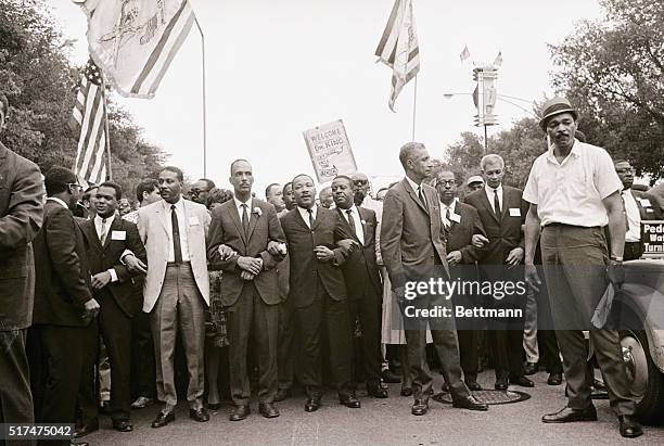 Dr. Martin Luther King, center, locks arms and forms a human chain, with fellow merchants as he leads then in march on City Hall here July 26. The...