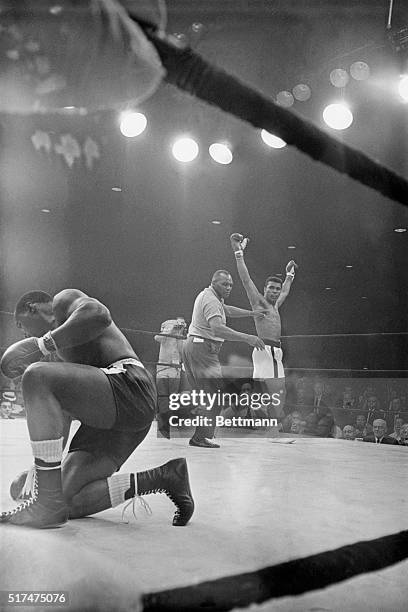 Referee Joe Wolcott guides heavyweight champion Muhammad Ali to a neutral corner after Ali downed challenger Sonny Liston in the first round of their...