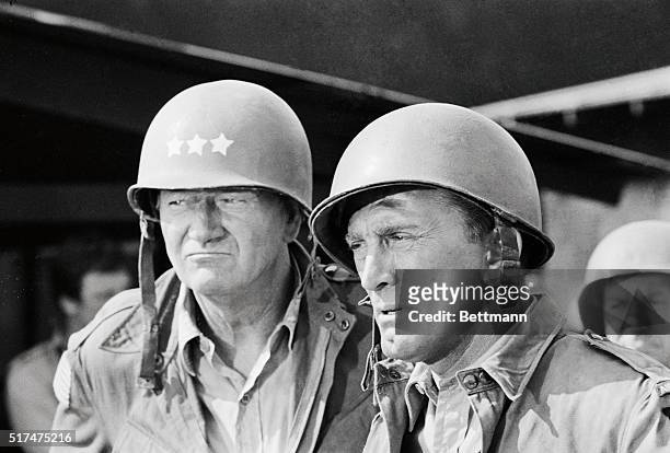 American actors John Wayne , as U.S. General Randolph, and Kirk Douglas, as US Colonel David Marcus, with helmets and military uniforms during a...