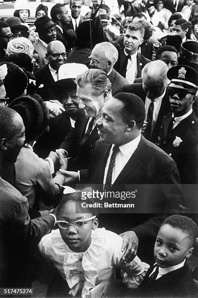 Atlanta: Dr. Martin Luther King, Jr., and Governor Nelson Rockefeller of New York shake hands with members of King's congregation outside the...