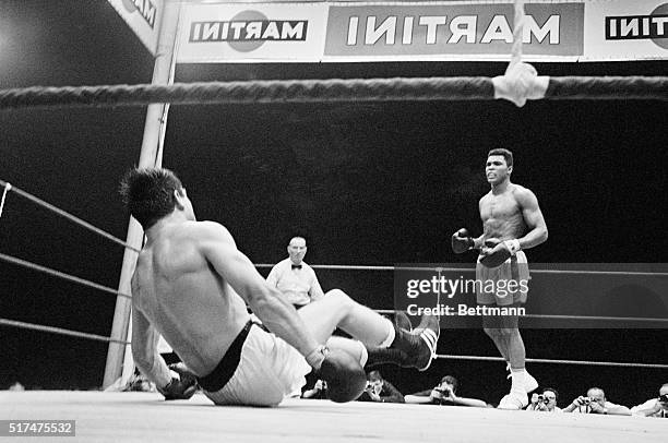 World Heavyweight Champion Cassius Clay watches as German challenger Karl Mildenberger slips to the canvas during the 5th round of their title bout...