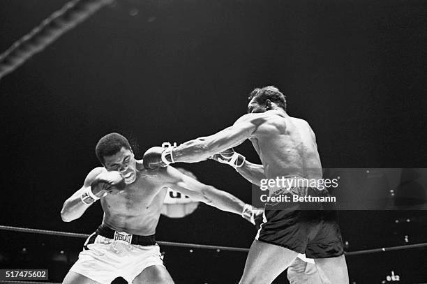 Challenger Cleveland Williams lands a left to champion Cassius Clay's head during first round action. Clay won by a third round TKO to retain crown.