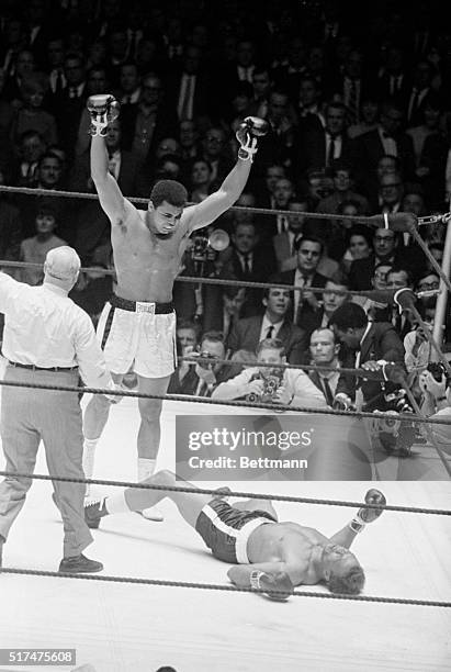 Heavyweight champion Cassius Clay raises his arms in a victory gesture after flattening challenger Cleveland Williams in second round of title fight...