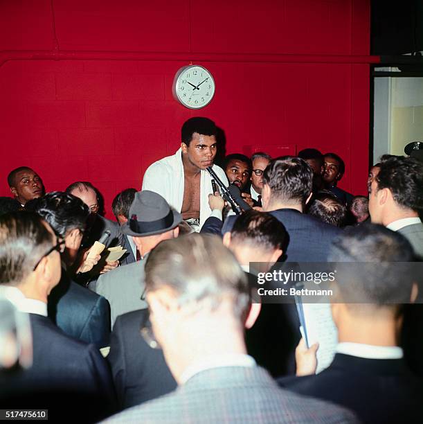 Muhammad Ali is interviewed by newsmen, in dressing room, following fight with challenger Cleveland Williams in which Ali retained his heavyweight...