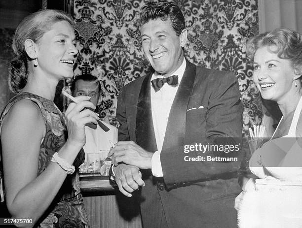 Rock Hudson, flanked by Lauren Bacall and Rhonda Fleming, seems to be enjoying himself. Now in Europe, Lauren has let it be known she will marry...