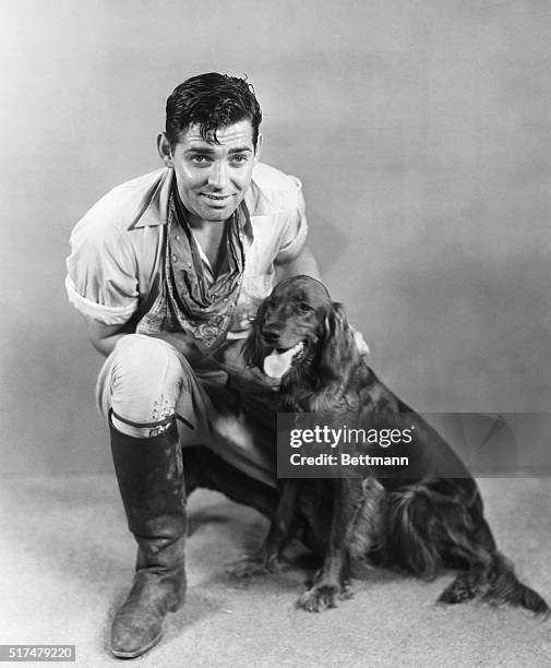 Clark Gable, Metro-Goldwyn-Mayer star, with his new pet, "Queen", an Irish setter. Mr. Gable's last appearance was with Jean Harlow in Red Dust,...