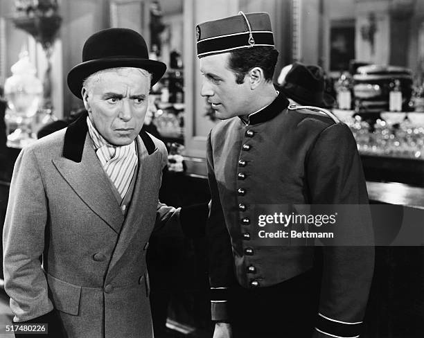 Charlie Chaplin plays a music-hall comedian, here speaking with a bell-boy, in the film, Limelight, released in 1951.