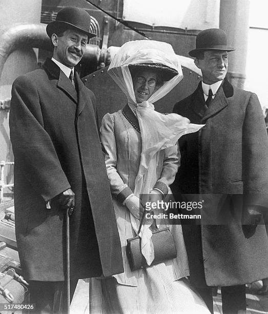 Inventors Orville and Wilbur Wright stand with their sister Katharine on the deck of a ship.