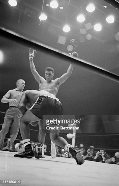 Las Vegas, Nev.:Cassius Clay raises both hands over his head and dances on one foot as Floyd Patterson gets up from the canvas after a mandatory...