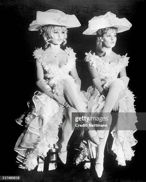 Brigitte Bardot, left, and Jeanne Moreau sing a risque French song as music hall performers in Louis Malle's Viva Maria, a United Artists release.