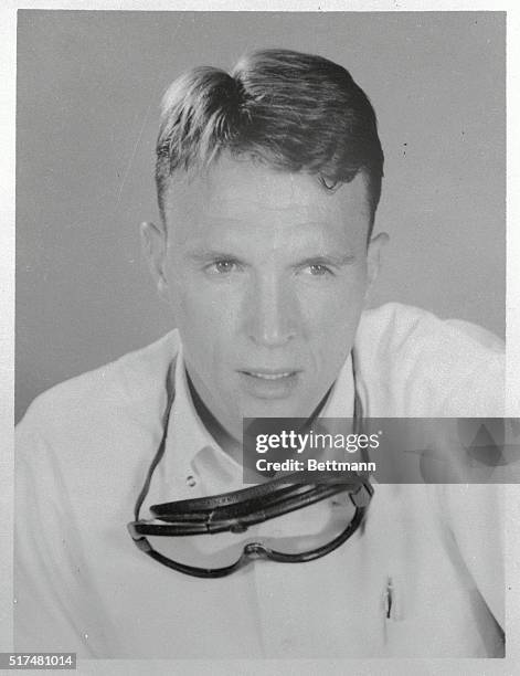 Portrait of race car driver Dan Gurney, of Costa Mesta, California. He is shown from the shoulders up, wearing driving goggles around his neck.