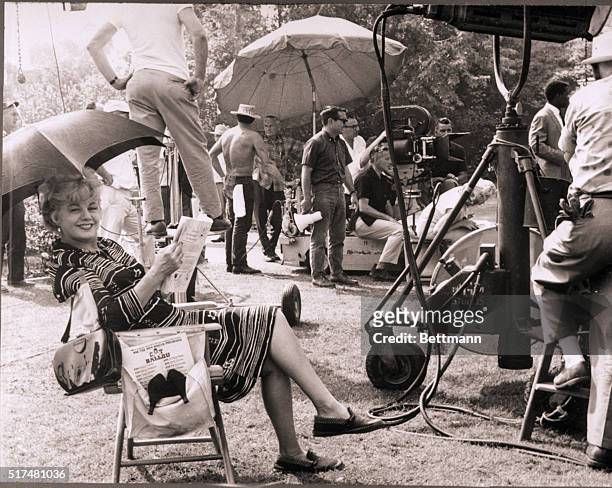 Hollywood, CA- Shelly Winters relaxes under an umbrella between shooting scenes for MGM's "A Patch of Blue." The veteran actress has received an...