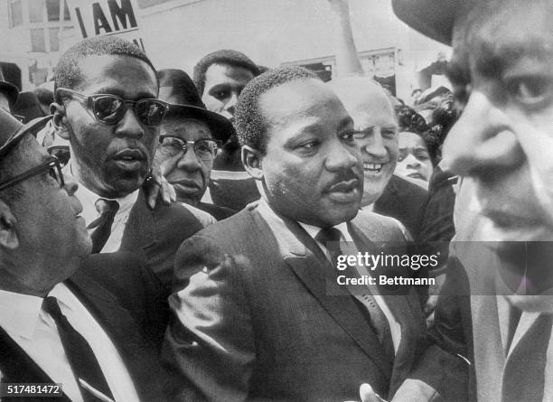 Dr. Martin Luther King is surrounded by leaders of the sanitation strike here as he arrived to lead a march in support of the striking workers....