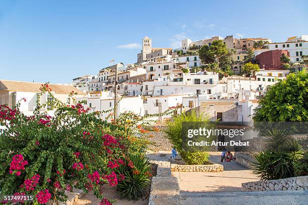 the ibiza old town with flowers on summertime. - ibiza foto e immagini stock