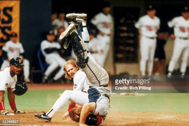 Dan Gladden of the Minnesota Twins looks back after colliding with the Atlanta Braves catcher at home plate during a game in the 1991 World Series at...