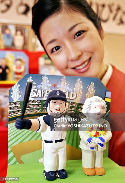 Japan's traditional doll maker Mataro Doll Craft employee Rie Saito displays 'kawaribina' or newsmakers dolls of this year, featuring dolls of...