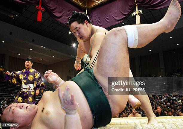 Sumo grand champion Asashoryu throws Iwakiyama to the ground during the third day bout of the 15-day long Kyushu Grand Sumo Tournament in Fukuoka,...