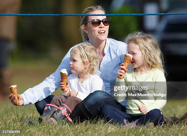 Autumn Phillips and daughters Isla Phillips and Savannah Phillips eat ice creams as they watch the show jumping during the Gatcombe Horse Trails at...