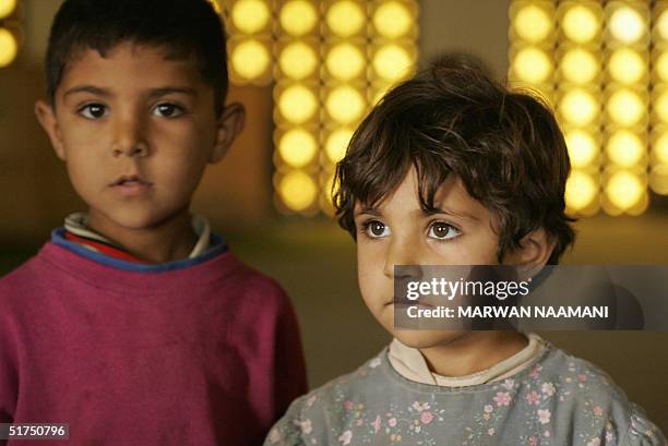 Siba and her brother Abdel Kader stand inside the al-Mustafa mosque in Baghdad 16 November 2004. Both children fled the devestated city of Fallujah,...