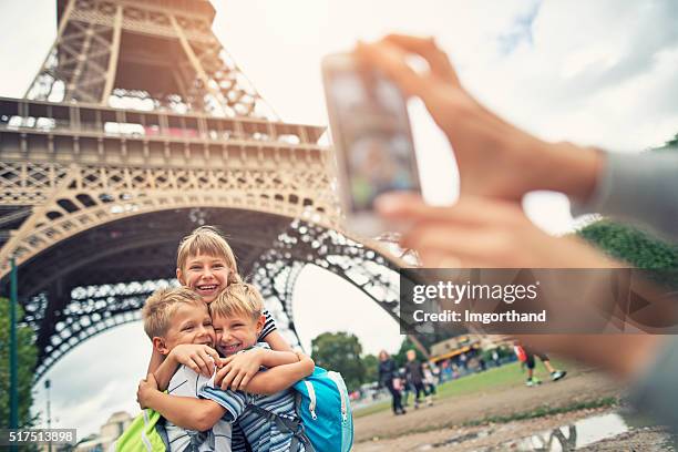 I turisti sorride alla macchina fotografica vicino alla Torre Eiffel
