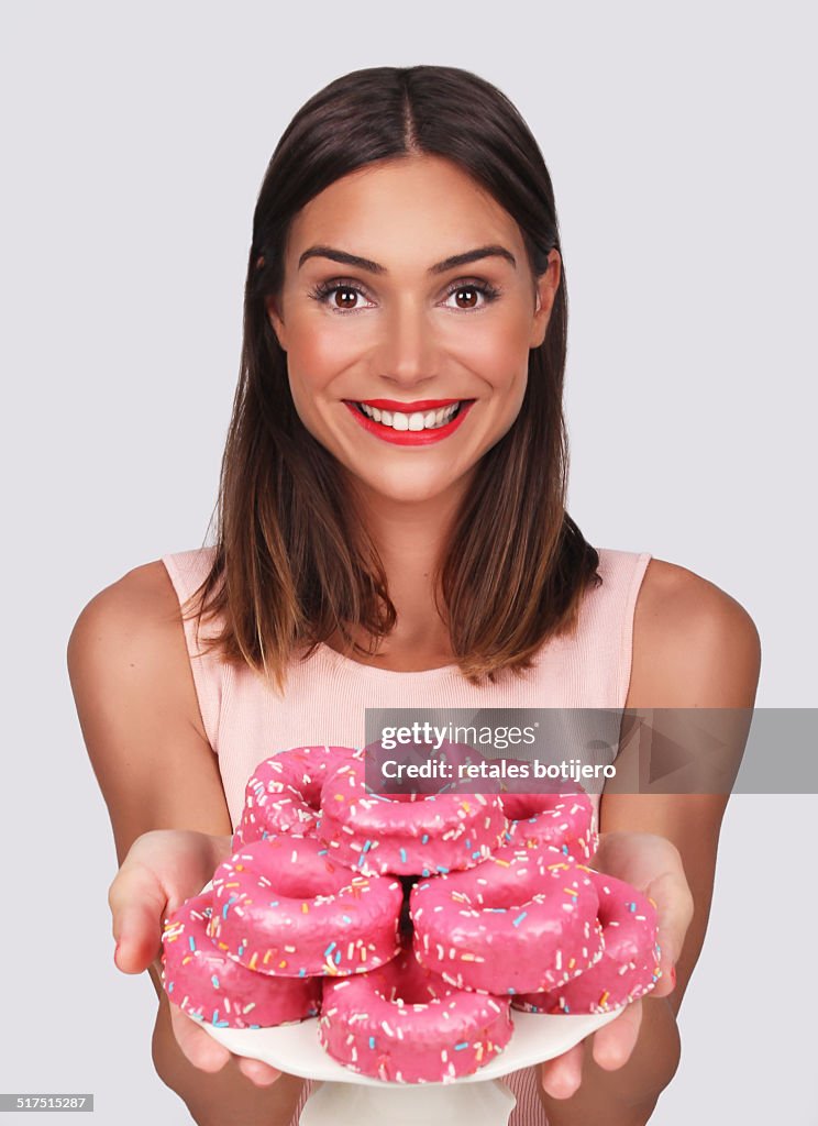 Woman offering pink donuts