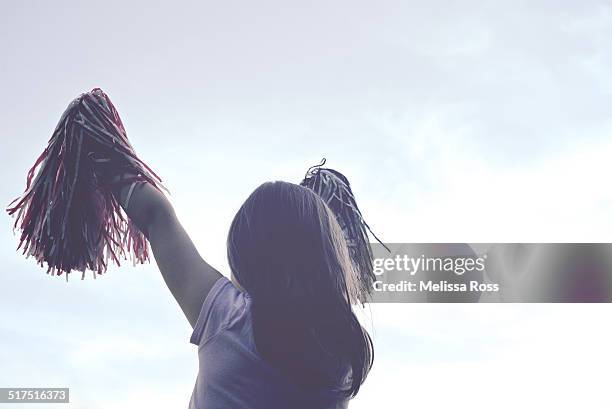 girl cheering with pom poms against the sky - white pom pom stock pictures, royalty-free photos & images