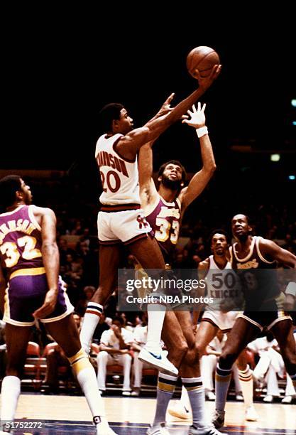 Micheal Ray Richardson of the New York Knicks drives to the basket for a layup against Kareem Abdul-Jabbar of the Los Angeles Lakers during a NBA...