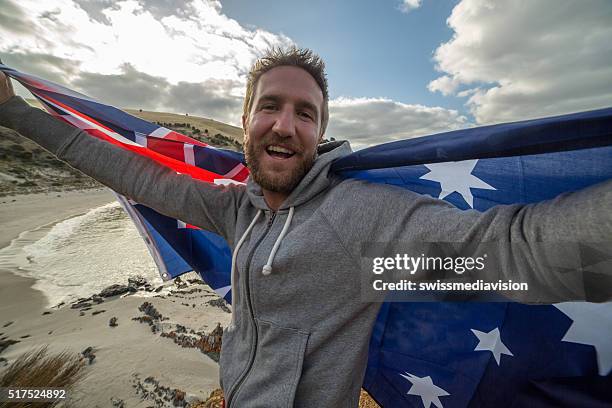 hombre joven en playa australiana de retención de la bandera - día de australia fotografías e imágenes de stock