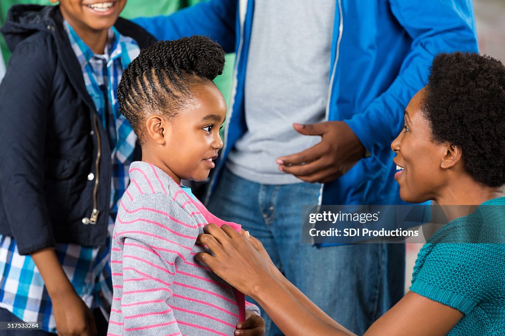 Little gril receives sweater at clothing drive