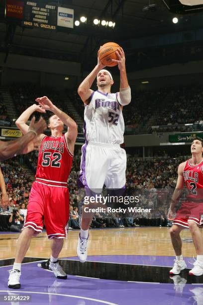 Brad Miller of the Sacramento Kings takes the ball to the basket against Eric Piatkowiski of the Chicago Bulls on November 16, 2004 at Arco Arena in...
