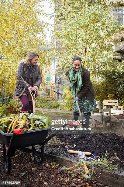 junge frauen sitzen in städtischen city garden, london, europa - carrot harvest black and white stock-fotos und bilder