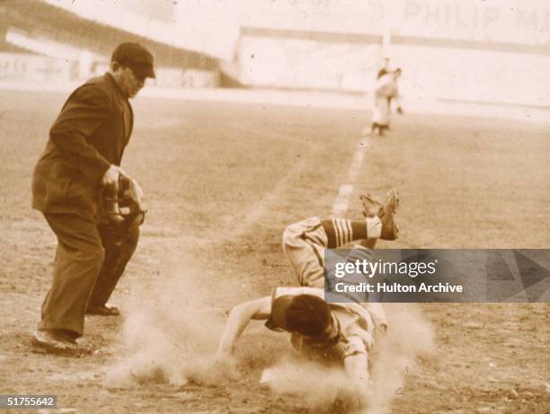 American professional baseball player Stan Musial, a rookie for the St. Louis Cardinals, slides into base during a game against the Atlanta Braves,...