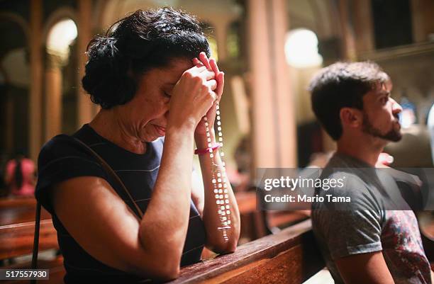 Woman prays with rosary beads in the Nossa Senhora da Paz church following a Good Friday procession during Semana Santa festivities on March 25, 2016...