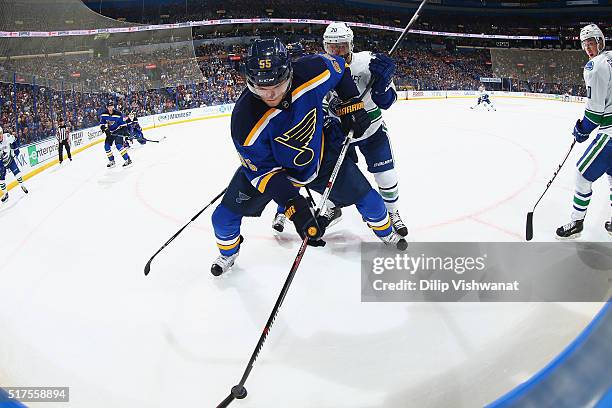 Colton Parayko of the St. Louis Blues beats Chris Higgins of the Vancouver Canucks to the puck at the Scottrade Center on March 25, 2016 in St....